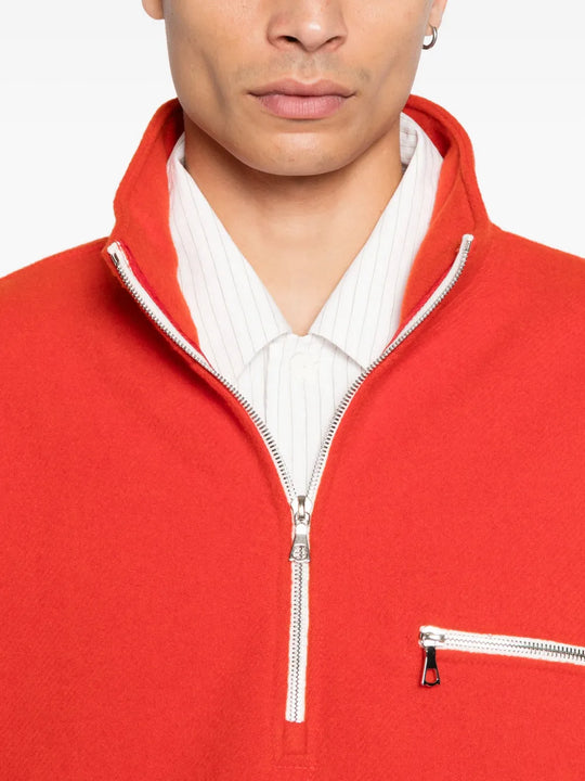 Close up of orange knitwear, showing texture of the wool fabric