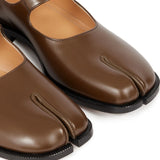 Close up of the brown shoes, showing texture of the leather fabric