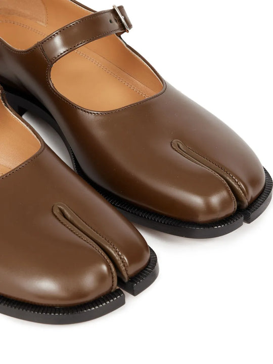 Close up of the brown shoes, showing texture of the leather fabric