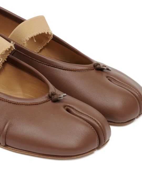Close up of the brown flats, showing texture of the leather fabric