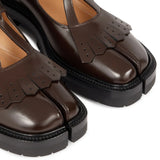 Close up of the brown shoes, showing texture of the leather fabric