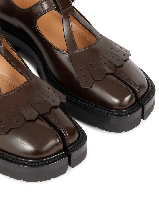 Close up of the brown shoes, showing texture of the leather fabric