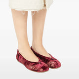 Red shoes worn by a person, showing the shoes' fit