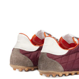 Close up of the red sneakers, showing texture of the suede and polyester fabric