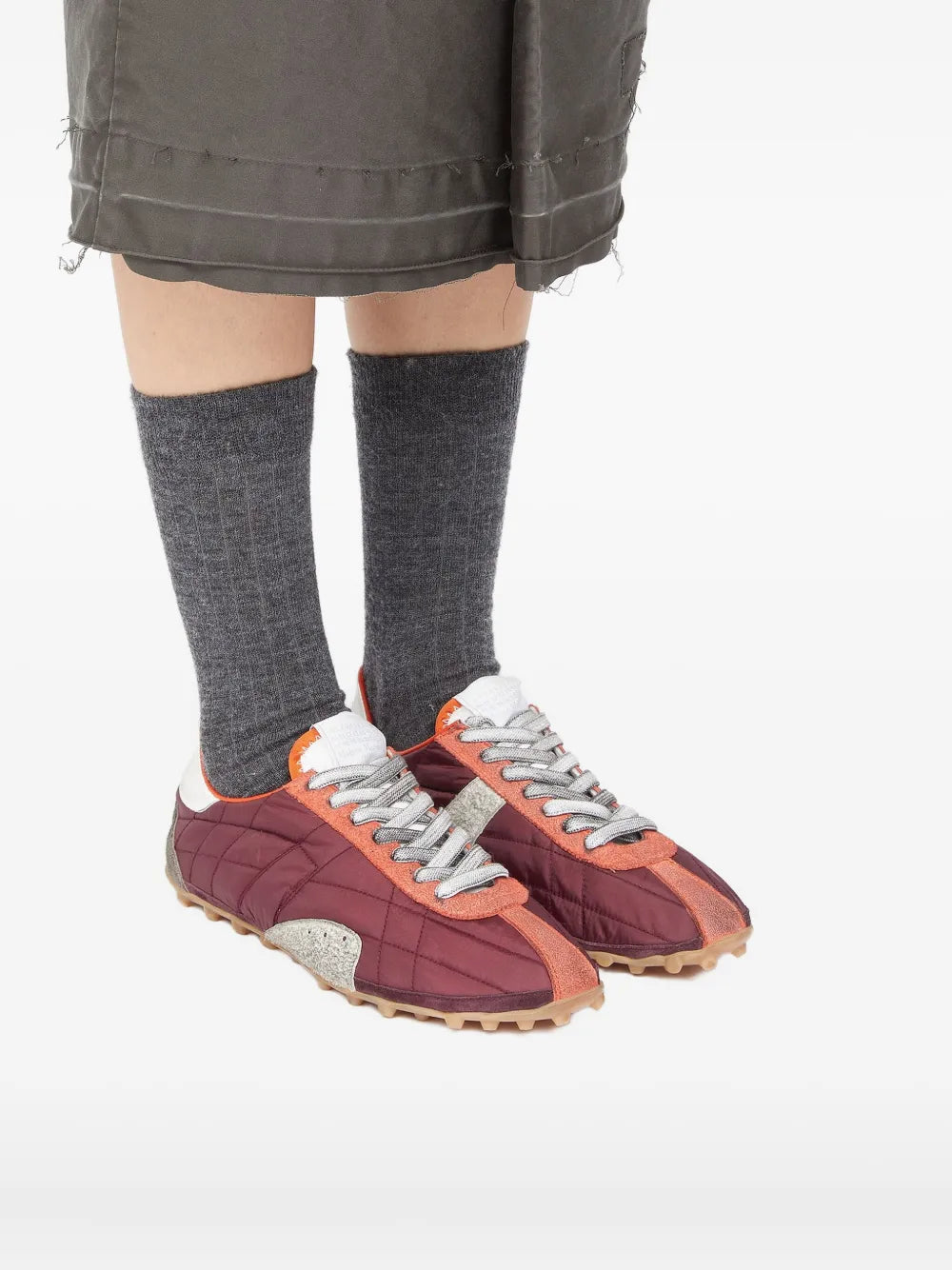 Red sneakers worn by a person, showing the sneakers' fit