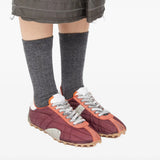 Red sneakers worn by a person, showing the sneakers' fit