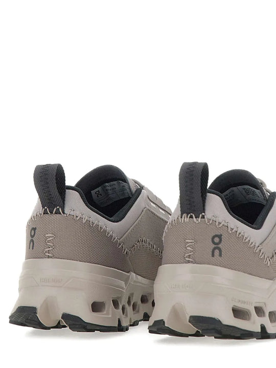 Close up of the grey sneakers, showing texture of the recycled polyester fabric