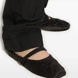 Black flat worn by a person, showing the flat's fit