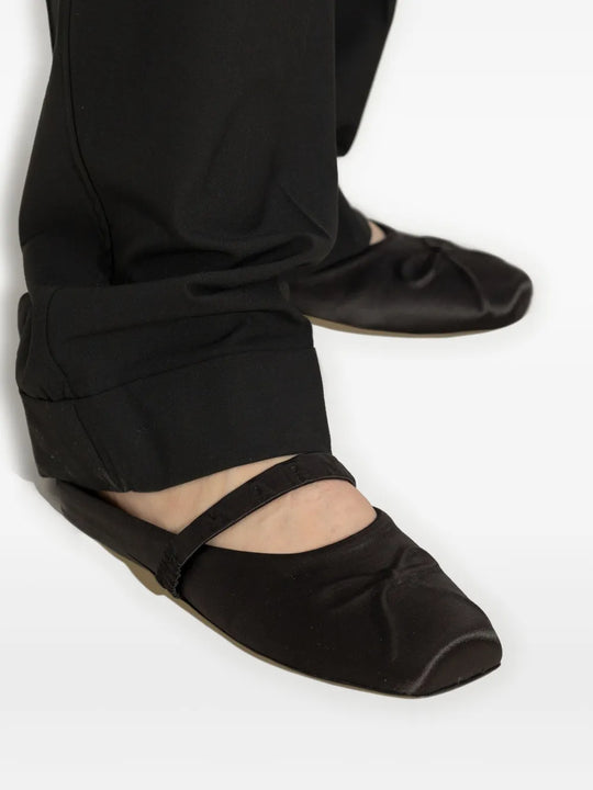 Black flat worn by a person, showing the flat's fit