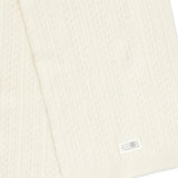 Close up of the white scarf, showing texture of the wool and acrylic fabric