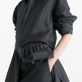 Close up of black dresses, showing texture of the silk fabric