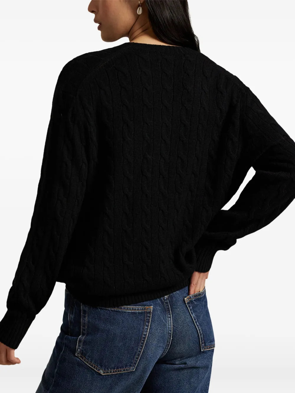 Black sweater worn by a person, showing the sweater's fit