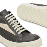 Close up of the grey sneakers, showing texture of the leather fabric