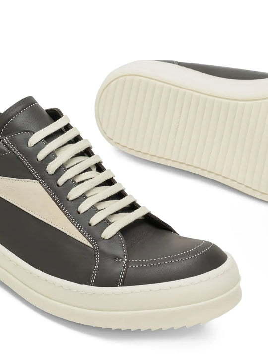 Close up of the grey sneakers, showing texture of the leather fabric