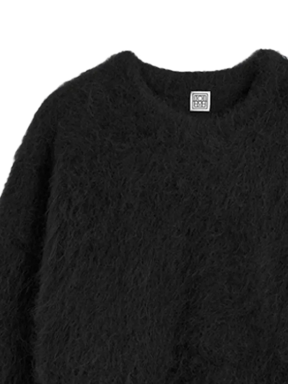 Close up of black knitwear, showing texture of the alpaca fabric