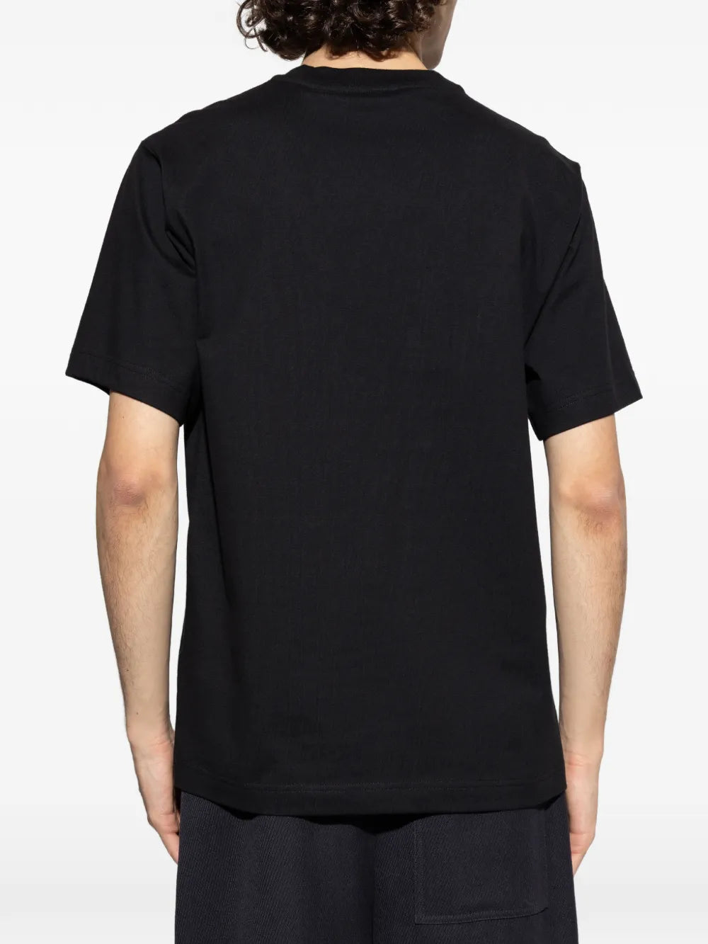 Black t-shirts worn by a person, showing the t-shirts fit