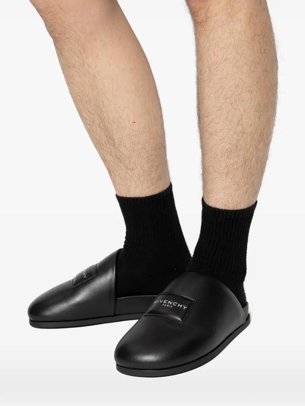 Black loafers-mules worn by a person, showing the loafers-mules'fit
