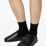 Black loafers-mules worn by a person, showing the loafers-mules'fit