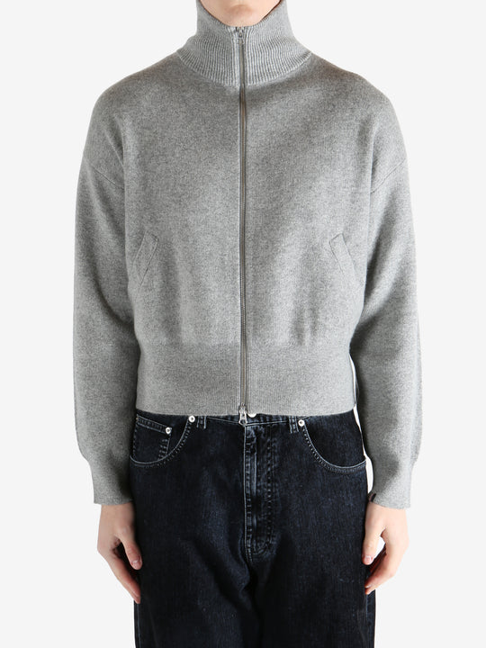 gray zip-up sweater worn by a person, showing the sweater fit