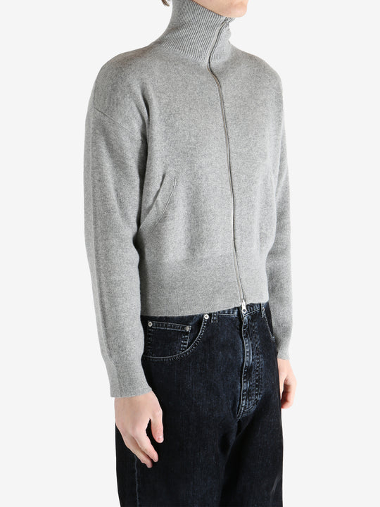 gray zip-up sweater worn by a person, showing the sweater fit