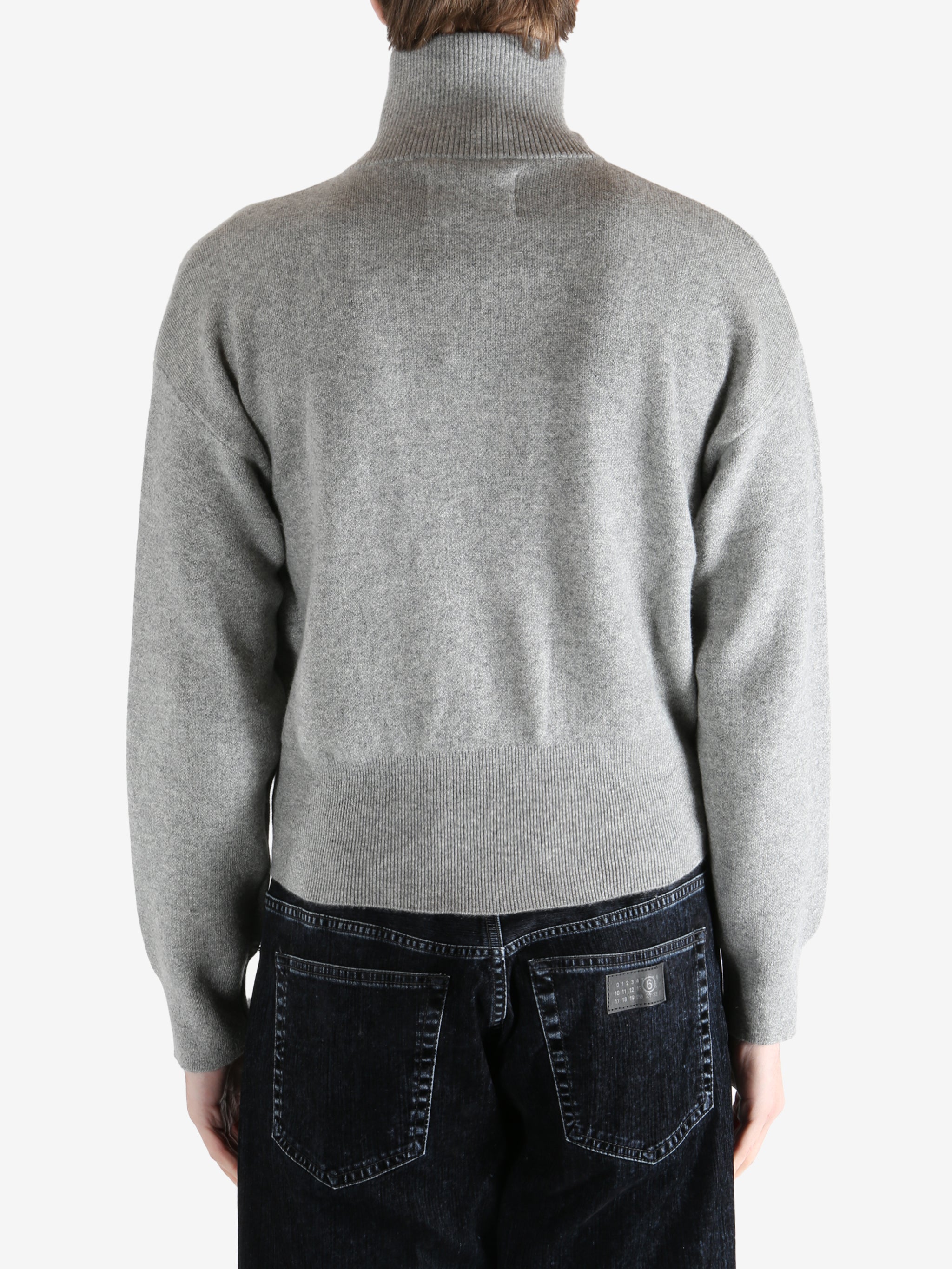gray zip-up sweater worn by a person, showing the sweater fit