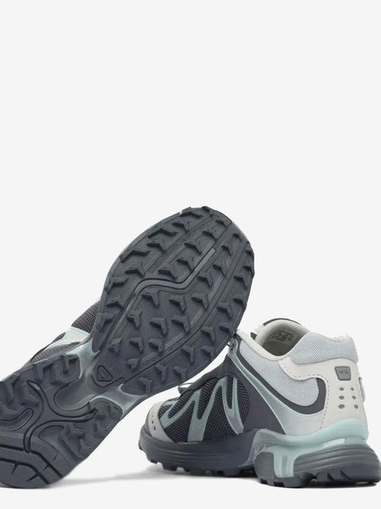 Close up of the grey sneakers, showing texture of the rubber fabric