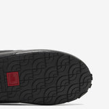 Close up of the black sneakers, showing texture of the rubber fabric