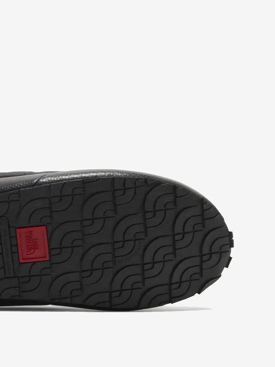 Close up of the black sneakers, showing texture of the rubber fabric