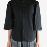 Black shirt worn by a person, showing the shirt's fit