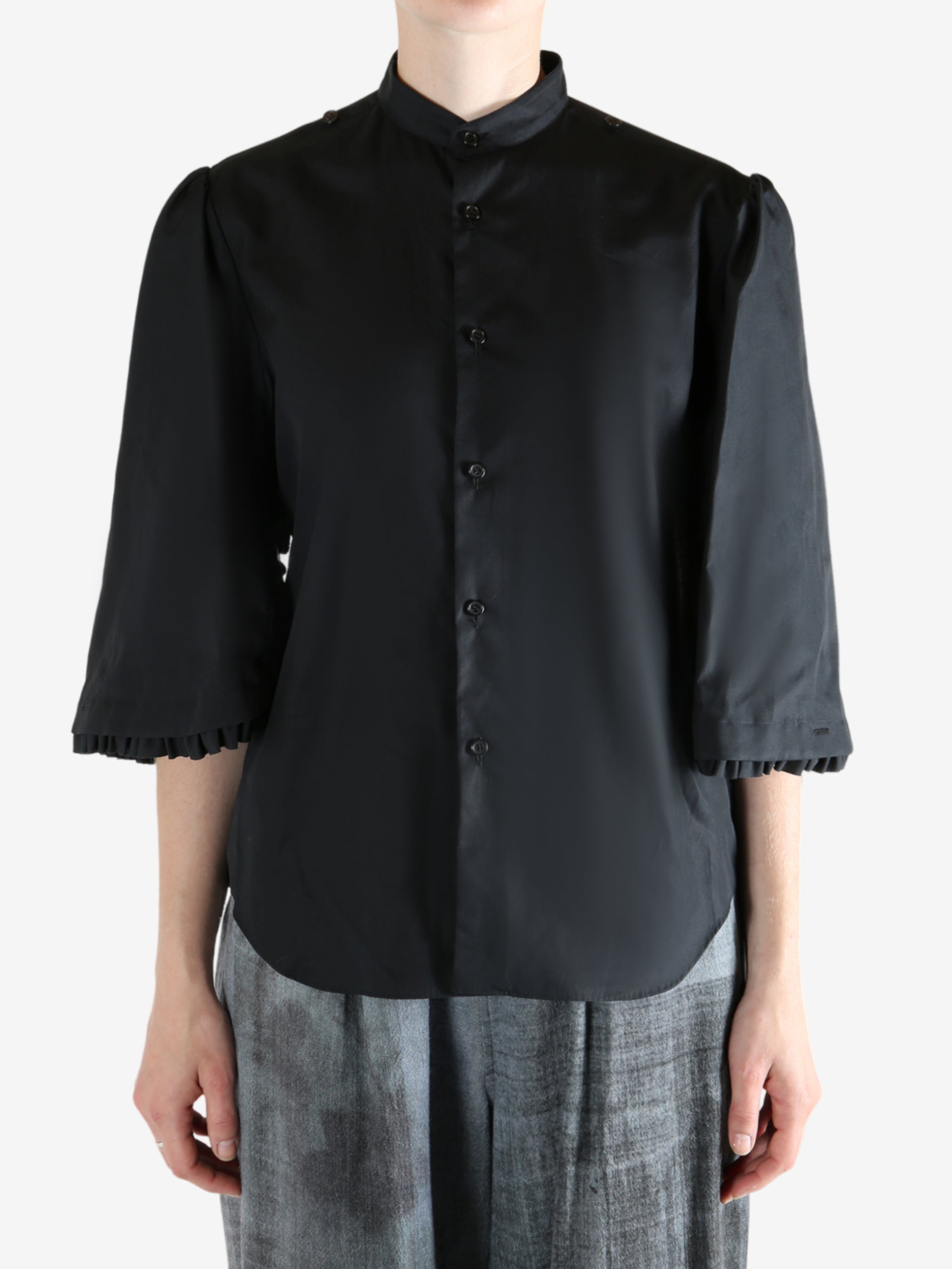 Black shirt worn by a person, showing the shirt's fit