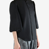 Black shirt worn by a person, showing the shirt's fit