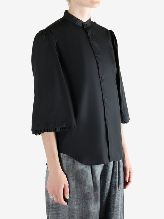 Black shirt worn by a person, showing the shirt's fit