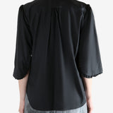 Black shirt worn by a person, showing the shirt's fit