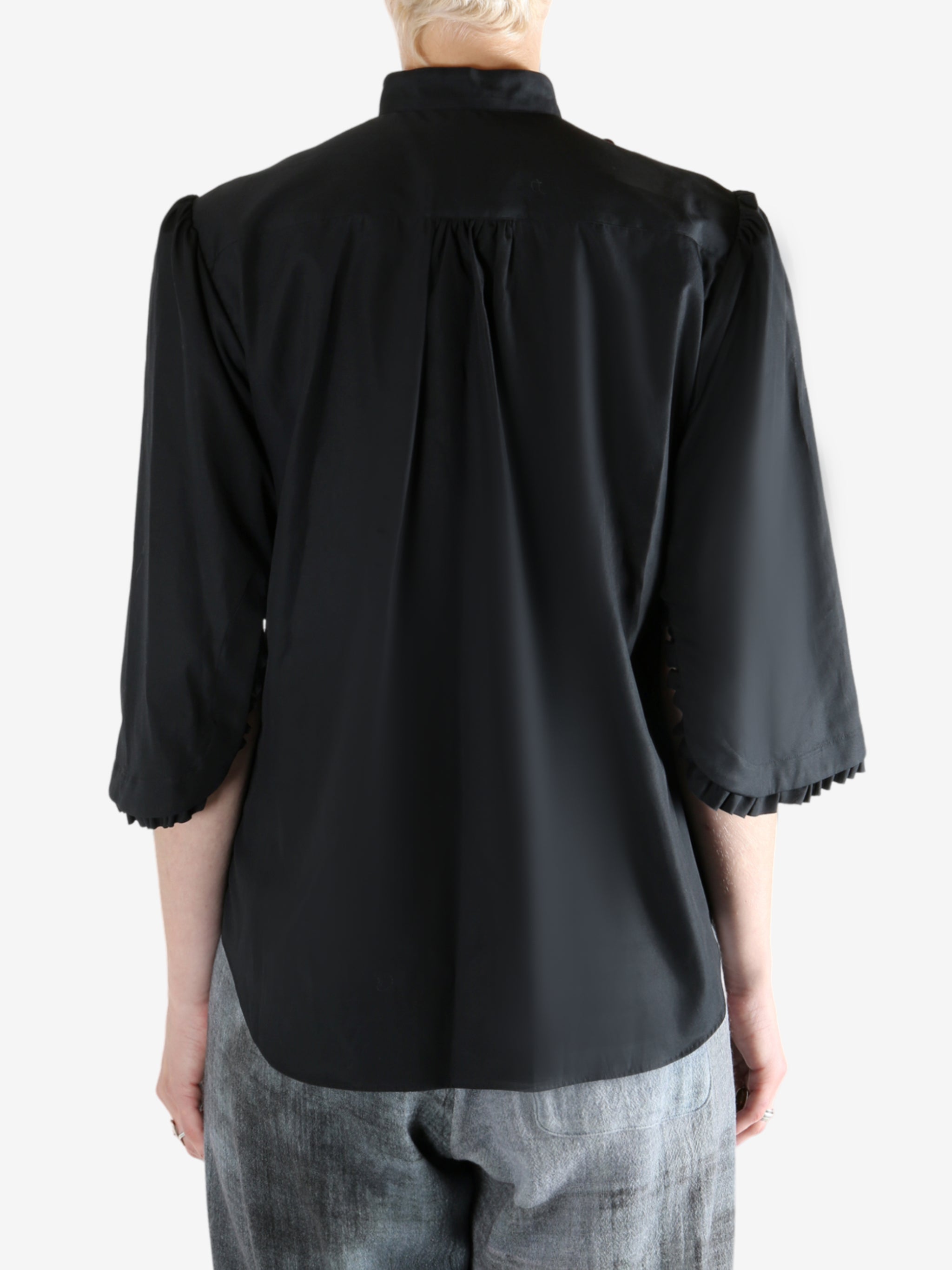 Black shirt worn by a person, showing the shirt's fit