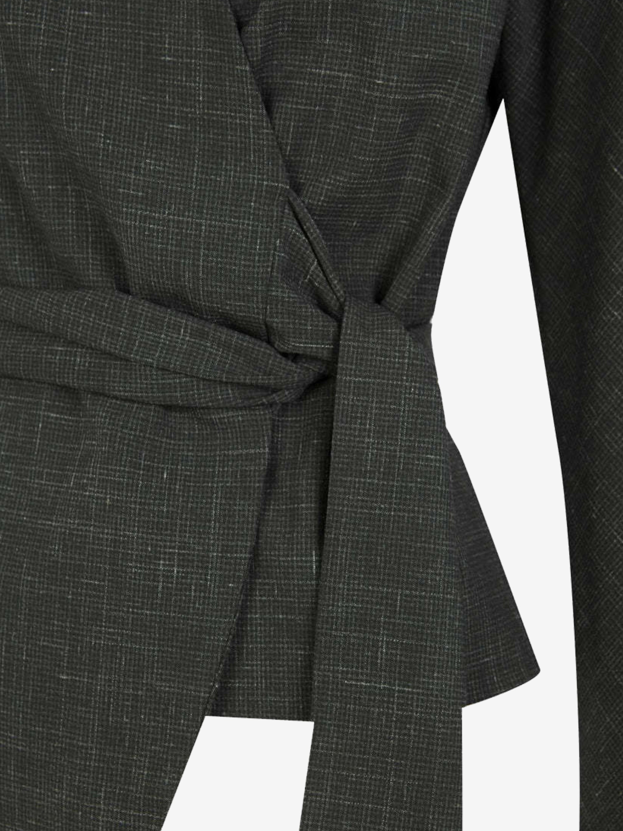 Close up of green jacket, showing texture of the virgin wool fabric