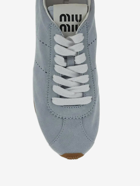 Close up of the blue sneakers, showing texture of the calf suede fabric