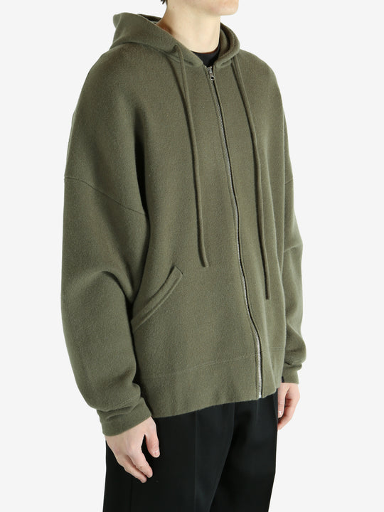 Green hoodie worn by a person, showing the hoodie's fit