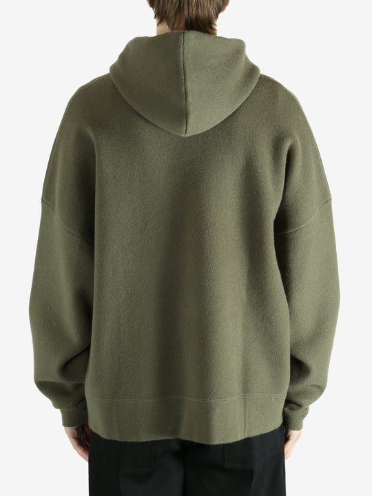 Green hoodie worn by a person, showing the hoodie's fit