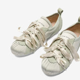 Close up of the green shoes, showing texture of the polyester and leather fabric