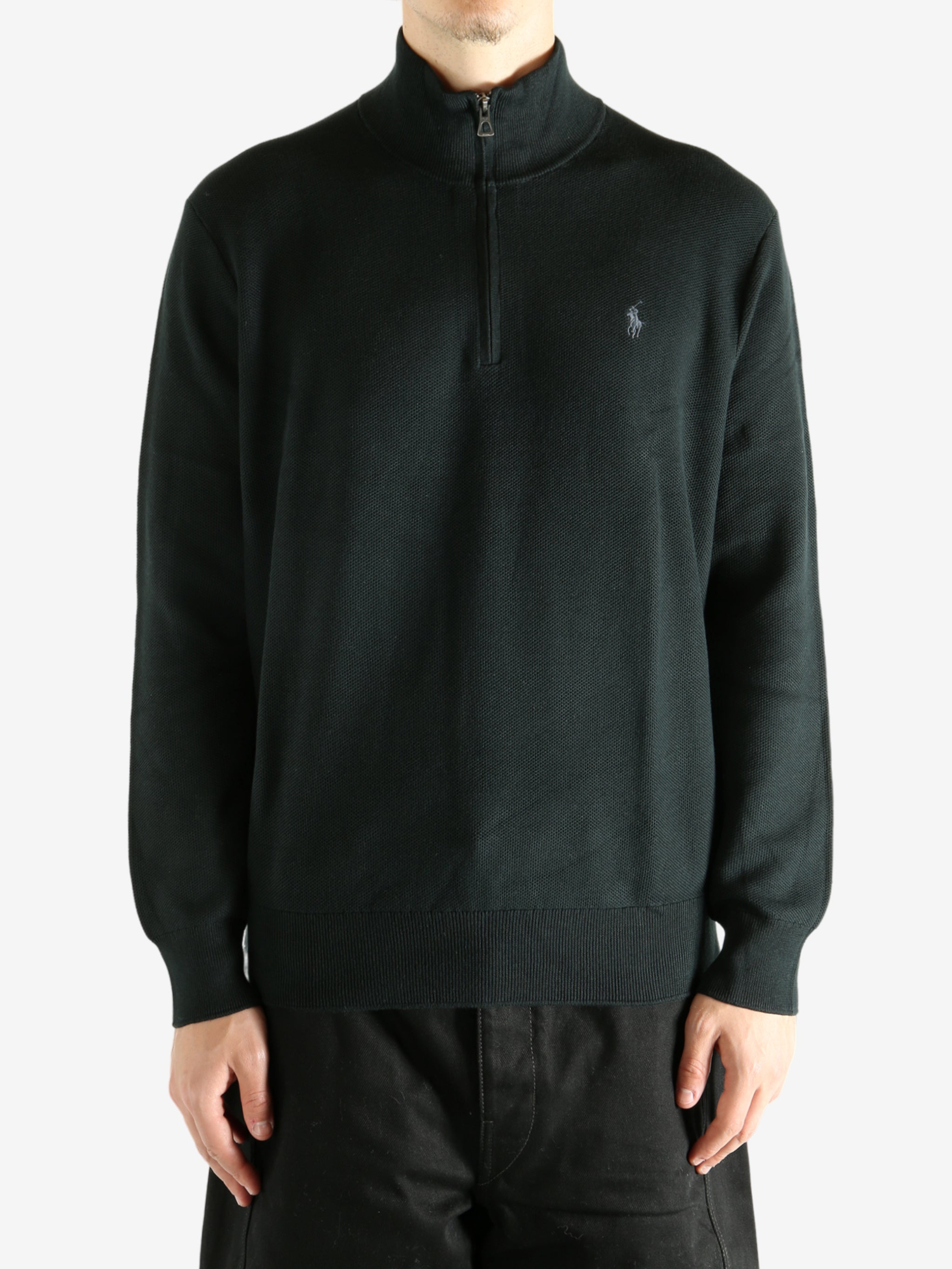 Black knitwear worn by a person, showing the knitwear's fit