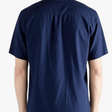 Navy shirts worn by a person, showing the shirts fit