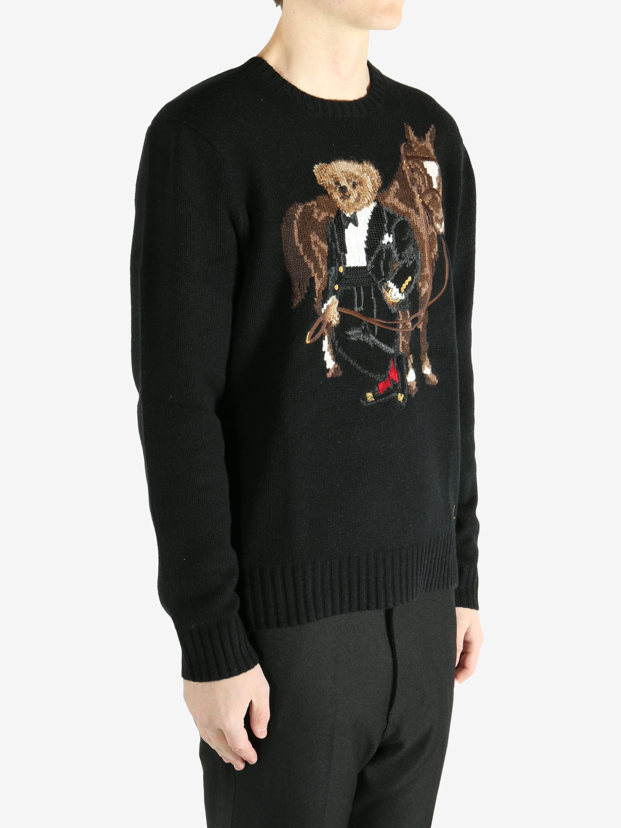 Black sweater worn by a person, showing the sweater's fit