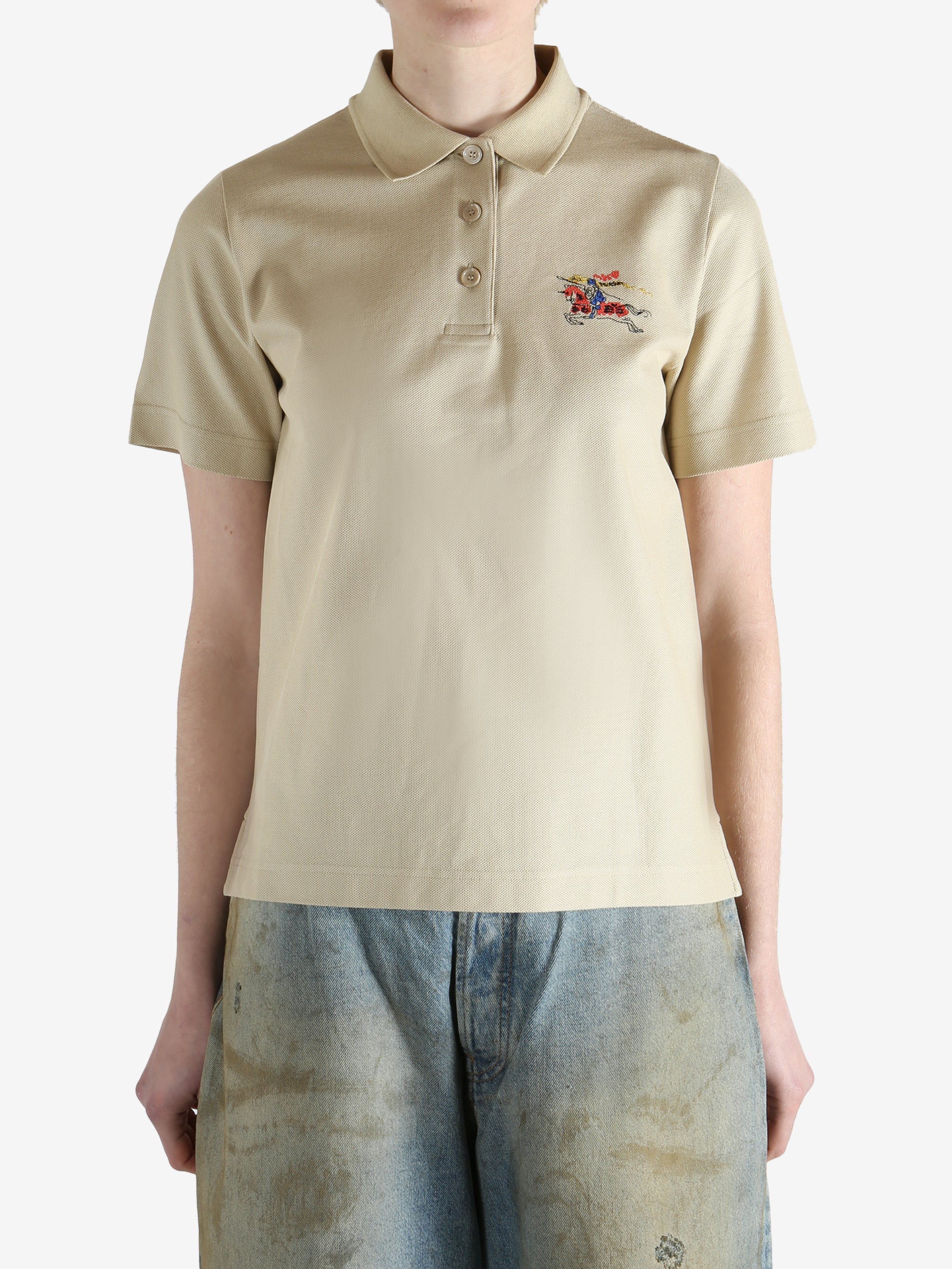 Beige polo shirt worn by a person, showing the shirt fit