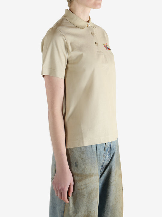 Beige polo shirt worn by a person, showing the shirt fit