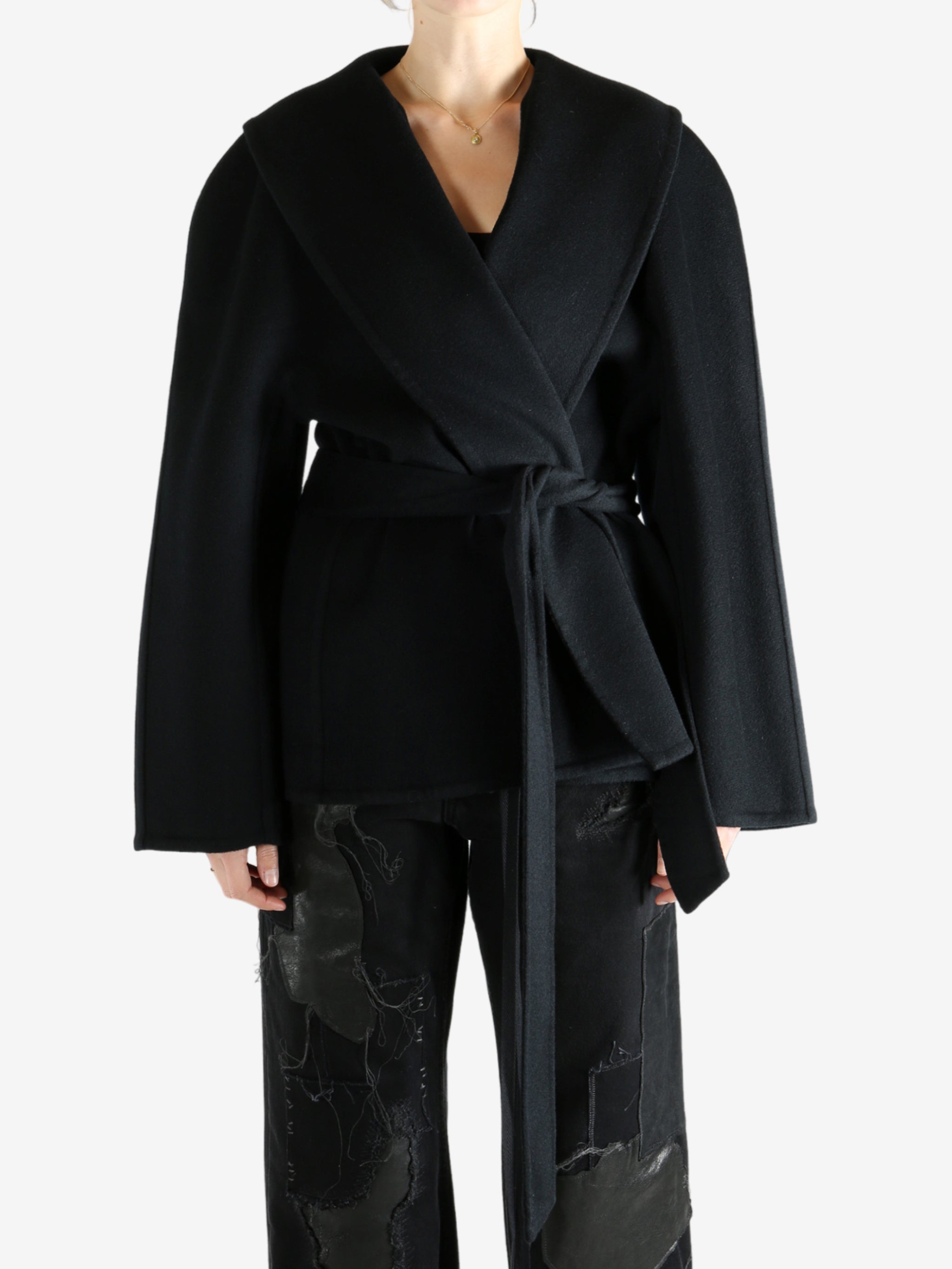 Black coat worn by a person, showing the coat fit