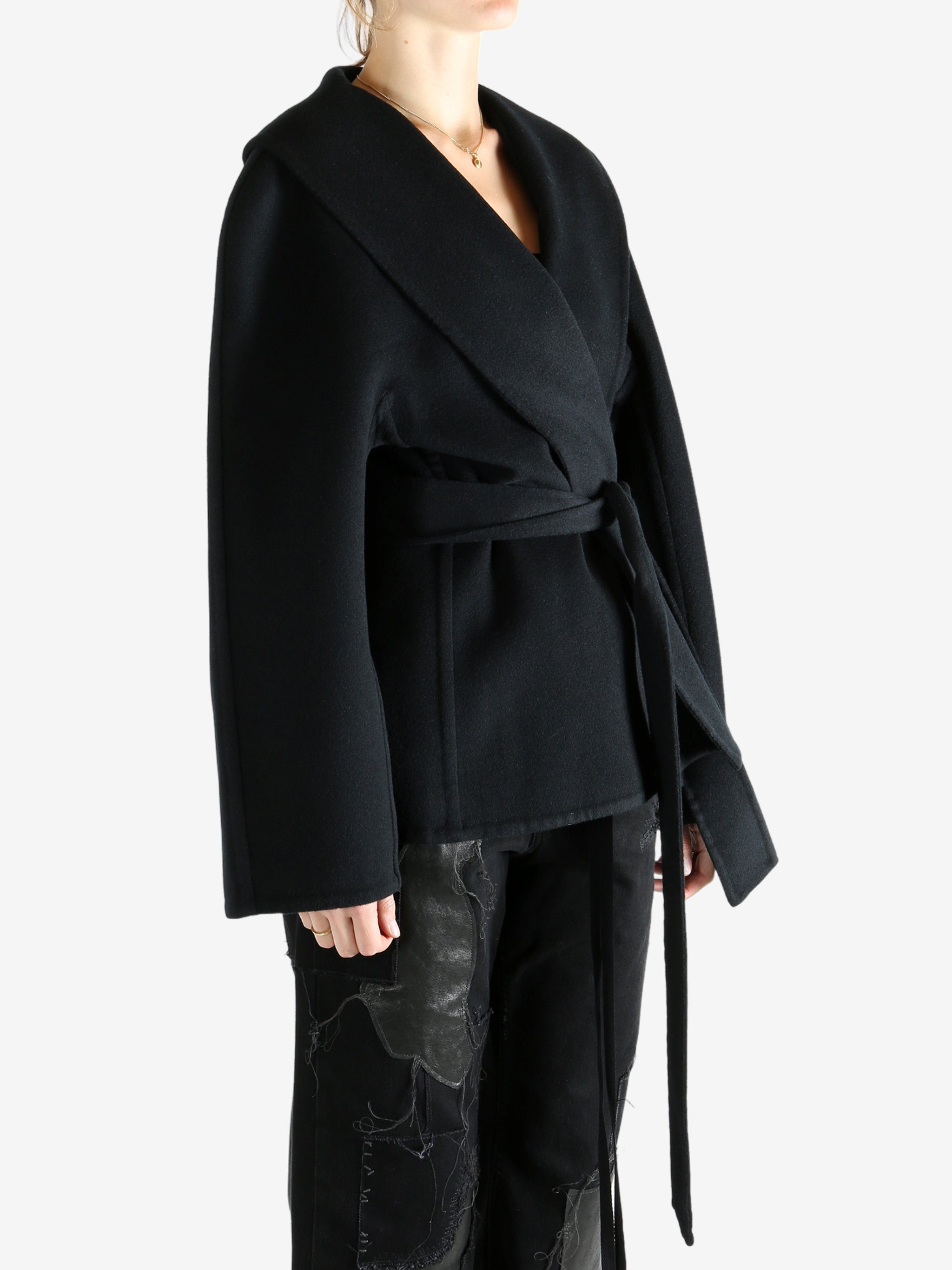Black coat worn by a person, showing the coat fit