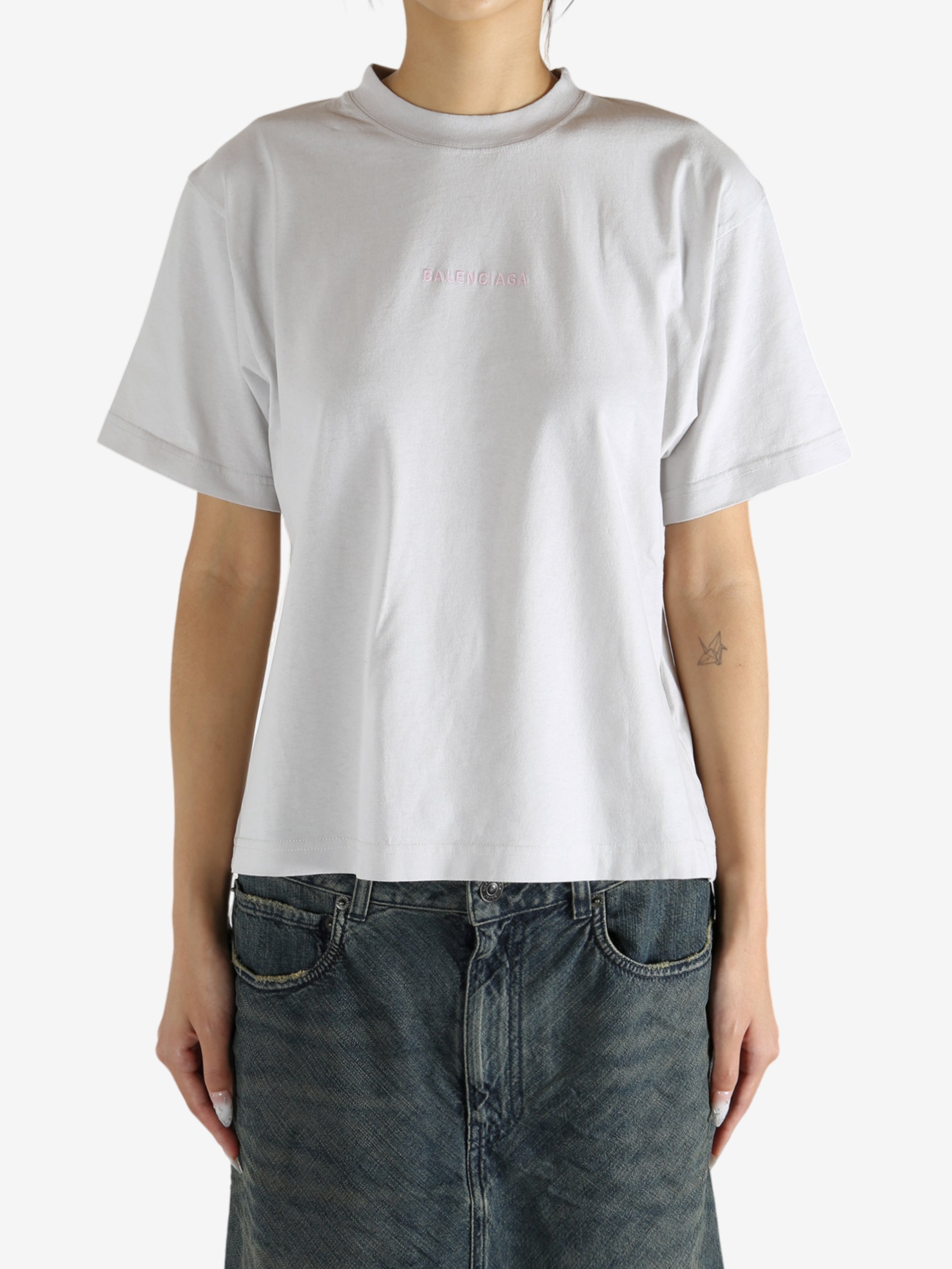White t-shirt worn by a person, showing the shirt's fit