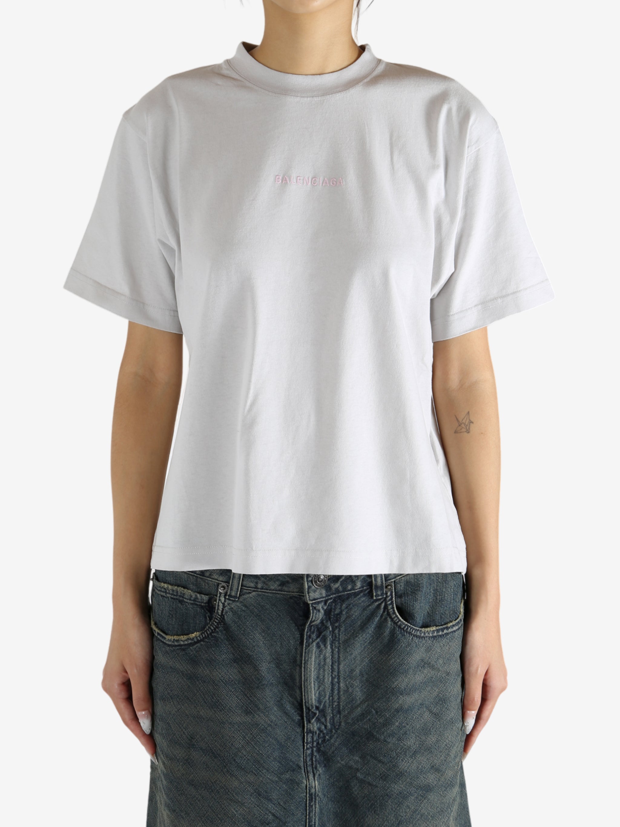 White t-shirt worn by a person, showing the shirt's fit