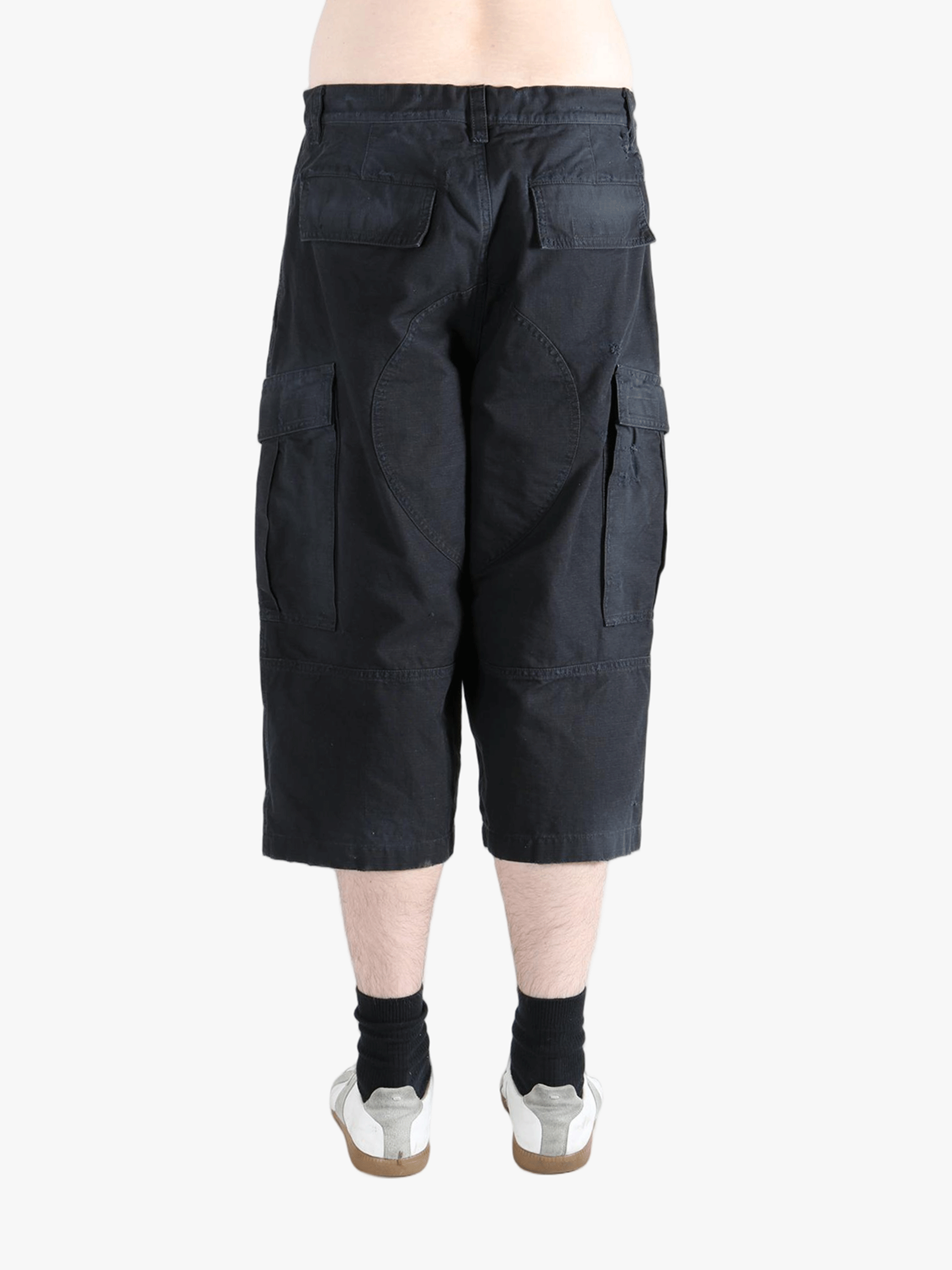 Black pants worn by a person, showing the pants' fit
