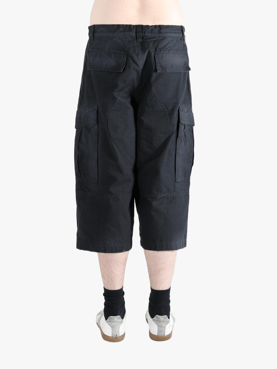 Black pants worn by a person, showing the pants' fit